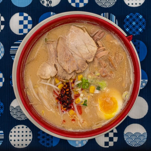 Tanpopo Ramen bowl with pork, corn, scallions, chili oil, and a soft-boiled egg.