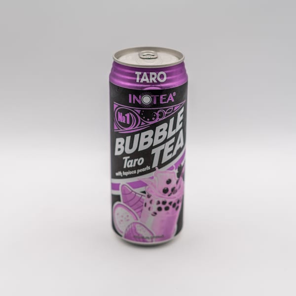 A purple and black can of Inotea Taro Bubble Tea with tapioca pearls.