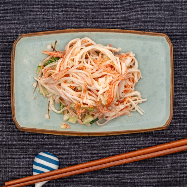 Tanpopo Ramen & Sushi Restaurant's crab salad with cucumber on a light blue rectangular plate with chopsticks.